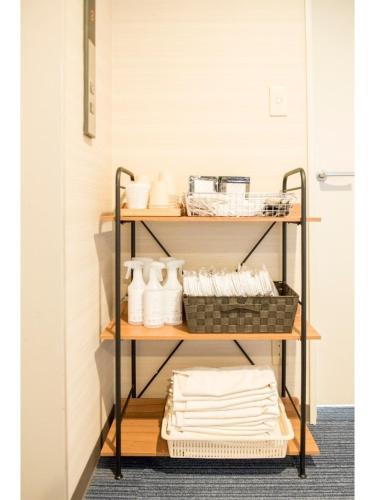 a shelf with white towels and baskets on it at Fujieda Ogawa Hotel フジエダオガワホテル in Fujieda