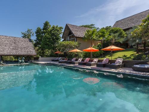 a swimming pool with chairs and umbrellas at Panacea Retreat in Bophut 