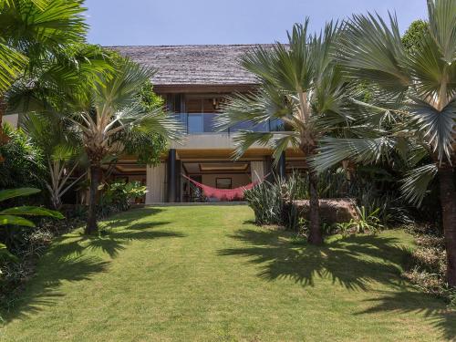a house with palm trees and a hammock in the yard at Panacea Retreat in Bophut 