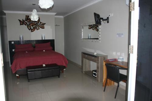 a bedroom with a red bed and a desk at Silver Fern Beach Retreat in Sekotong