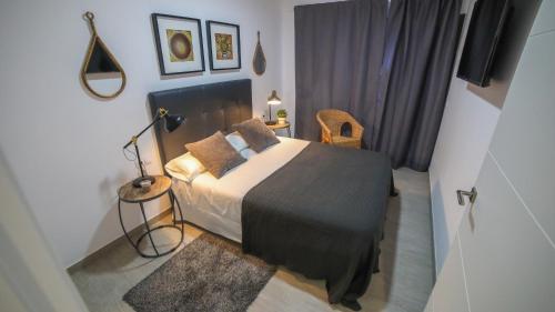 a bedroom with a bed and a table and a lamp at Brazan Holidays in Corralejo