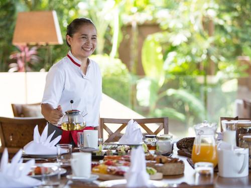 a woman standing in front of a table with food at Panacea Retreat in Bophut 