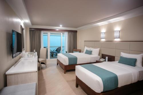 a hotel room with two beds and a view of the ocean at Boracay Mandarin Island Hotel in Boracay