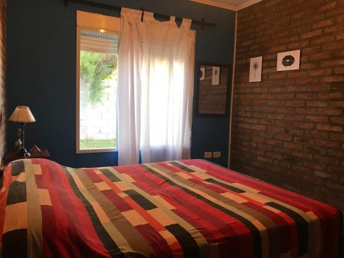 1 dormitorio con 1 cama colorida y ventana en MSH Apart, en Puan