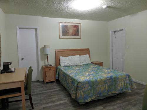 a bedroom with a bed and a table and a desk at Travelers Inn - Clearwater in Clearwater