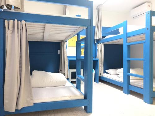 1 dormitorio con literas azules en una habitación en Slow Citi Guest House en Seogwipo