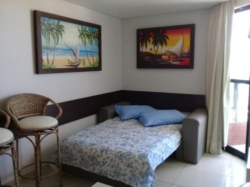 una camera da letto con un letto e una sedia di Flat Marinas - Cabo Branco - João Pessoa a João Pessoa