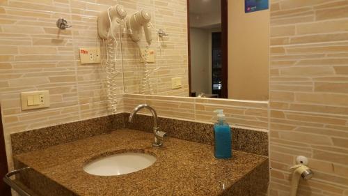 un lavandino in bagno con una bottiglia di sapone blu di Flat Marinas - Cabo Branco - João Pessoa a João Pessoa