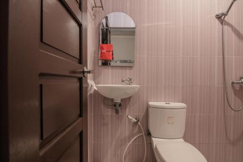 y baño con aseo y lavamanos. en RedDoorz Syariah Plus @ Banjarbaru en Banjarmasin