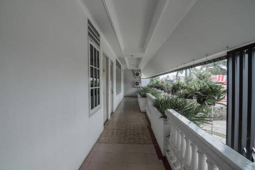a corridor of a building with potted plants at RedDoorz Syariah Plus @ Banjarbaru in Banjarmasin