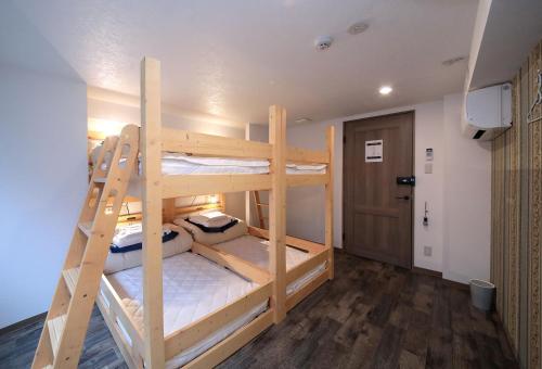 Trip & Sleep Hostel في ناغويا: سريرين بطابقين في غرفة