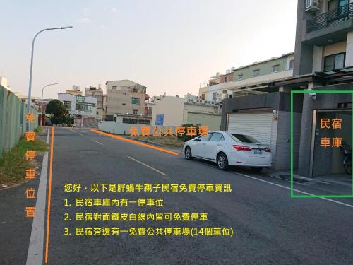 a white car parked on the side of a street at 胖蝸牛親子民宿 in Tainan