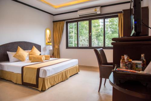 a hotel room with a bed and a window at Poseidon Boutique Hotel in Pattaya South