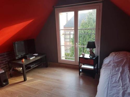 ein Schlafzimmer mit einem Bett und einem großen Fenster in der Unterkunft Logis la Rotourelle in Torcy-le-Grand