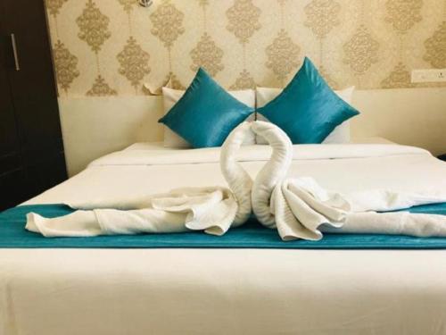 una cama con dos cisnes hechos de toallas en SRM Tower Residency, en Guruvāyūr