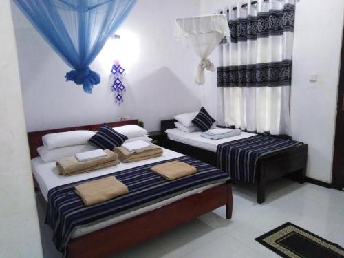 a bedroom with two beds and a window at Asiri HomeStay in Sigiriya