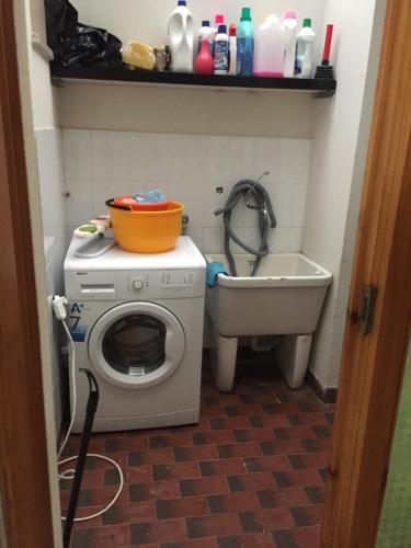 a small bathroom with a washing machine and a sink at Casa mia in Su Forti