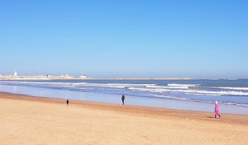 a group of people walking on the beach at Maison d'hôtes Cité Portugaise in El Jadida