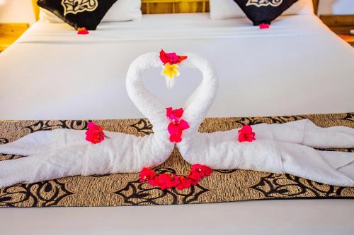 two swans made out of towels on a bed at Suba Homestay in Nusa Lembongan