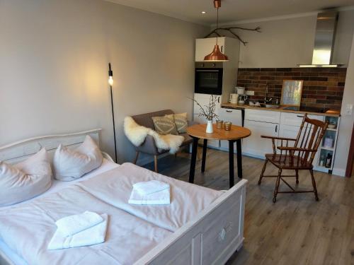 グリュックスブルクにあるApartment Strandkorbのベッドルーム1室(ベッド1台付)、キッチン、テーブルが備わります。