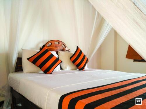 um quarto com uma cama com almofadas cor de laranja e preta em Ella River Face Inn em Ella