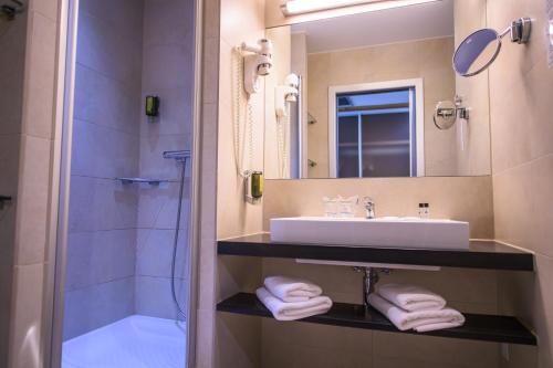 a bathroom with a sink and a mirror and a shower at HOTEL Bioterme Mala Nedelja in Ljutomer