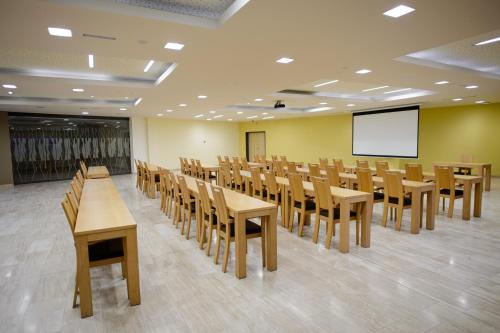 a lecture room with tables and chairs and a screen at HOTEL Bioterme Mala Nedelja in Ljutomer