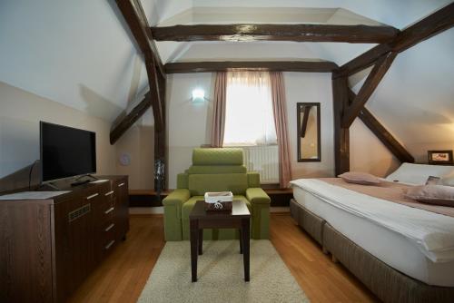 a bedroom with a bed and a chair and a television at Sobe Bernarda in Varaždinske Toplice
