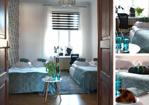 two beds in a room with a window and a table at Marilyn Apartment in Łódź