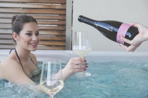 a woman in a bath tub holding a glass of wine at HOTEL Bioterme Mala Nedelja in Ljutomer