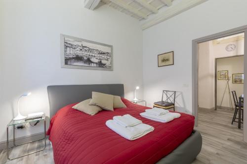 フィレンツェにあるPonte Vecchio's Nestのベッドルーム1室(赤いベッド1台、タオル2枚付)