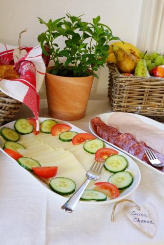 a plate of food with cucumbers on a table at Adventure Guesthouse Interlaken in Interlaken