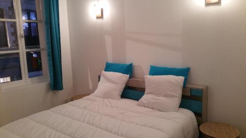 - une chambre avec 2 lits dotés d'oreillers bleus et blancs dans l'établissement Le Saint-Pry, à Béthune