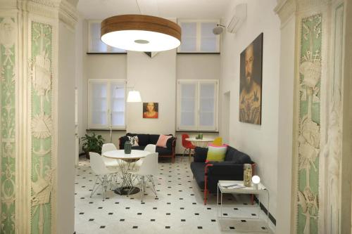 a living room with a table and chairs at Hotel Le Nuvole Residenza d'Epoca in Genoa