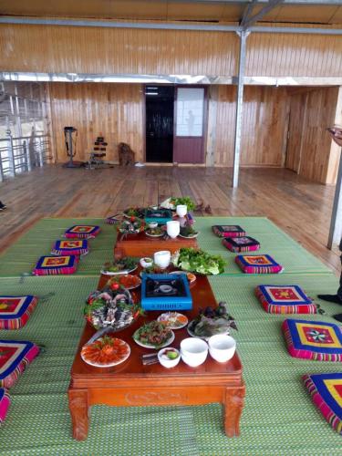 a table filled with plates of food on a floor at Nhà hàng Nhà nghỉ Dù Lượn Khau Phạ in Mù Cang Chải