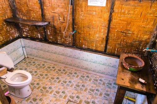 a dirty bathroom with a toilet and a table at Horizon Eco Resort in Ko Phra Thong