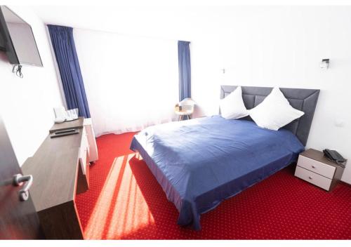 ポイアナ・ブラショフにあるPrincess Butiqueのベッドルーム(青いベッド1台、薄型テレビ付)