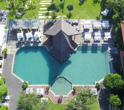 una vista sul soffitto di una grande piscina con sedie intorno di Sadara Resort a Nusa Dua