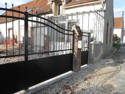 a wrought iron gate with a brick pillar at Chez Denise in Champaubert