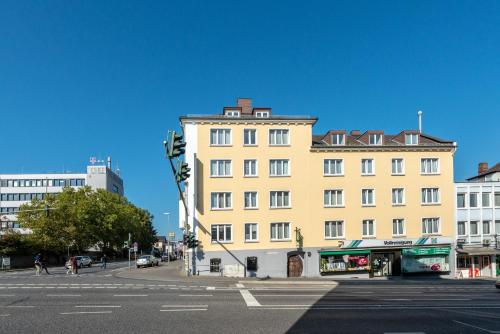 ein großes gelbes Gebäude an der Ecke einer Straße in der Unterkunft Liebig-Hotel in Gießen