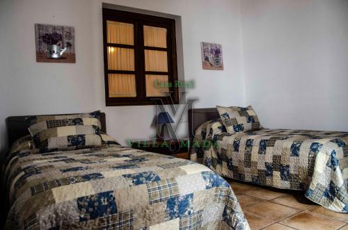 El Real de la JaraにあるCasa Rural VILLAMADAのベッド2台と窓のある寝室