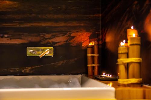 a close up of a bath tub in a room with candles at The Nowness Luxury Hotel & Spa in Çeşme