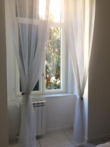 a window with white curtains in a room at Live Naples in Naples
