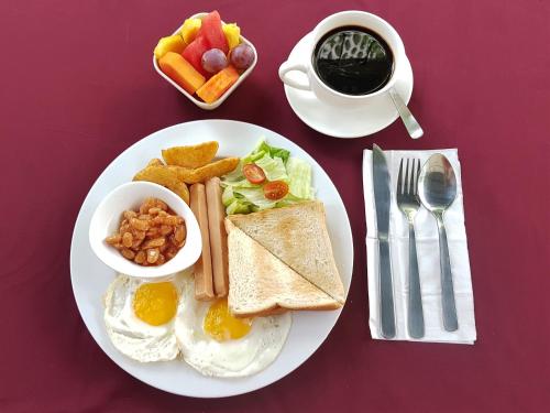 a plate of breakfast food with eggs toast and coffee at Prima Hotel Melaka in Melaka