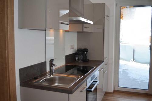 kuchnia z umywalką ze stali nierdzewnej i oknem w obiekcie Zugspitzappartements w mieście Ehrwald