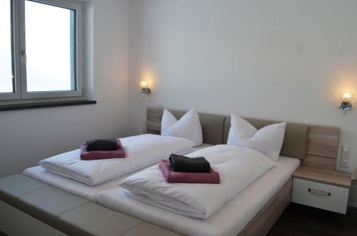 białe łóżko z dwoma poduszkami w obiekcie Zugspitzappartements w mieście Ehrwald