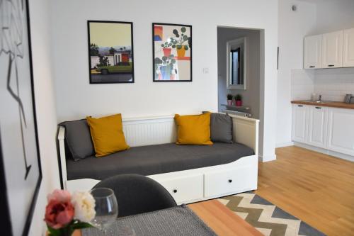 ein Wohnzimmer mit einem Sofa und gelben Kissen in der Unterkunft Apartamenty Coco Premium Saska Kępa in Warschau