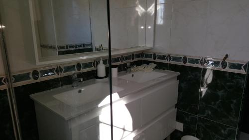 une salle de bains avec un lavabo blanc et un miroir dans l'établissement VILLA ROMA, à Gignac-la-Nerthe