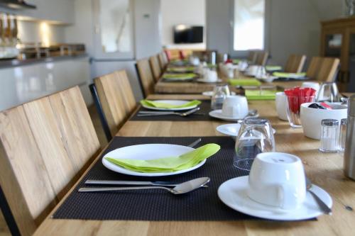 a wooden table with plates and napkins on it at Villa Valkenburg in Valkenburg