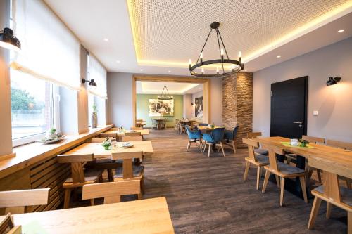 a dining room with wooden tables and chairs at Parkhotel Nordwalde in Nordwalde